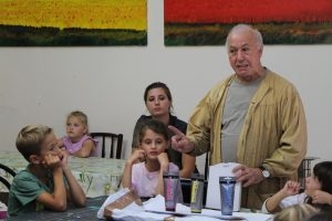 Maler Salvatore Orrù erklärt den Kindern, wie man Farbe mischt.