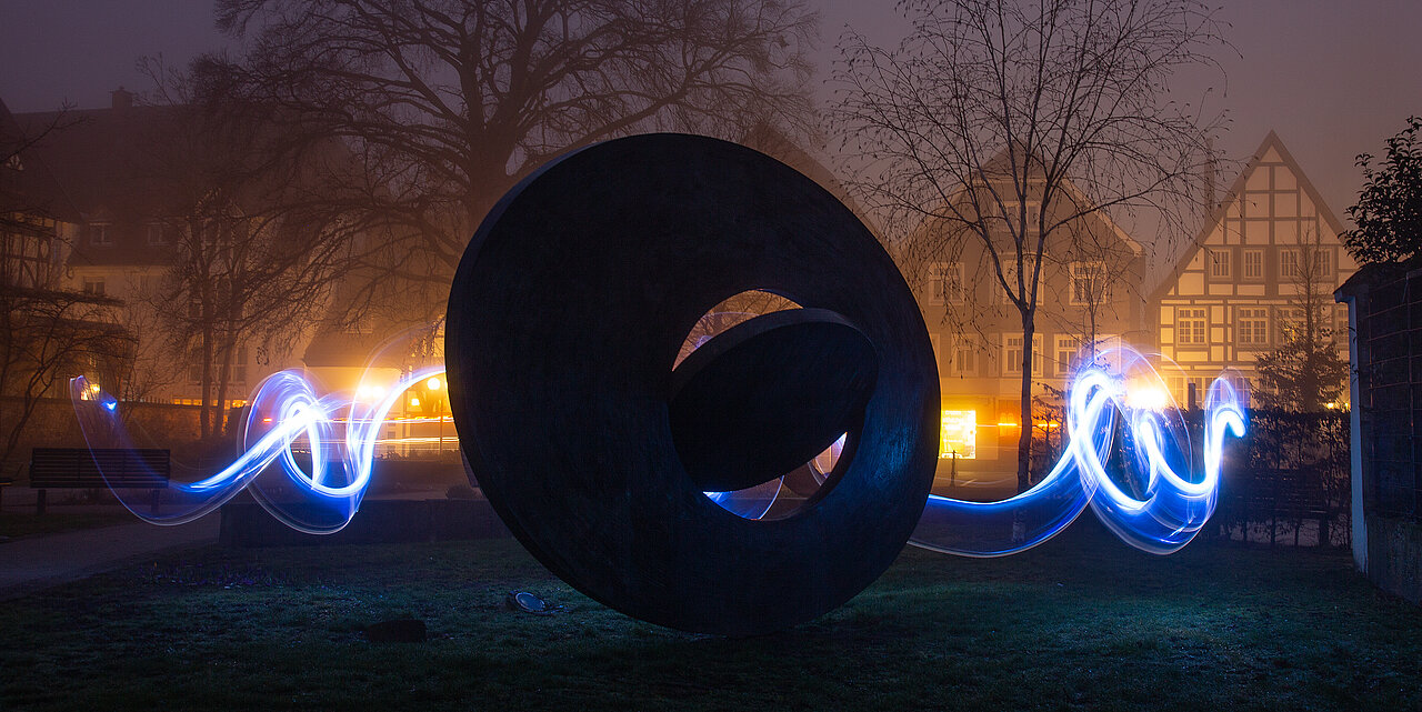Kunstwerk "Fluctuation of forces" von Ernst Hesse im Lippstädter Postpark bei Nacht und beleuchtet