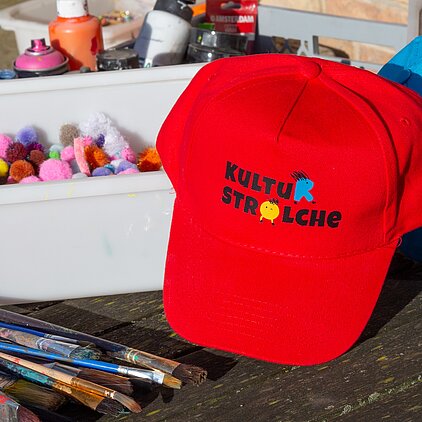 Rote Basecap mit Kulturstrolchelogo